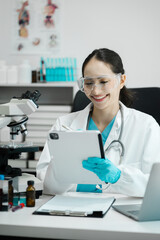 Chemist scientist holding tablet analyzing samples conducting experiment in laboratory with equipment, science concept.