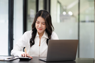 Women are using calculators to calculate office income.