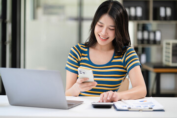 lifestyle of office workers Woman calculating expenses and using laptop. Home office. Work place. Lifestyle.