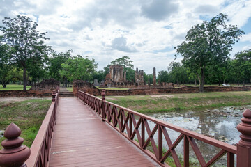 Obraz premium A wooden bridge crosses a small canal to reach the island.