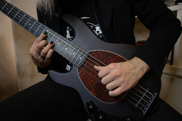Fototapeta na wymiar Guitarist, guitar, gothic, painted nails, black clothes, close-up