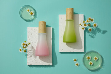 Two bottles in pink and green color put on stone podiums. Petri dishes of essential oil and...