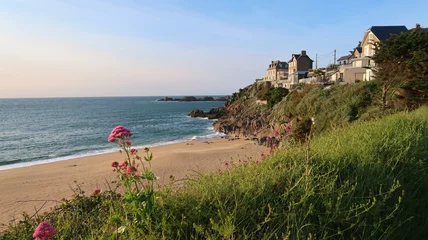 Plage du Val à Rothéneuf, dans la ville de Saint-Malo en Bretagne, paysage de côte avec une plage déserte de sable fin, de l’herbe et des maisons sur la falaise, au bord de la mer (France) © Florence Piot