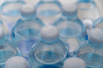 Transparent plastic bottles, containing water, next to each other. Use and recycling of plastic.
