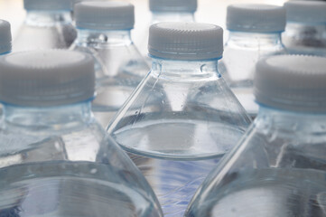 Transparent plastic bottles, containing water, next to each other. Use and recycling of plastic.
