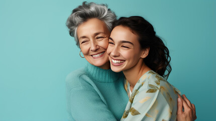 Happy mother and daughter smiling and hugging against the blue background. - Powered by Adobe