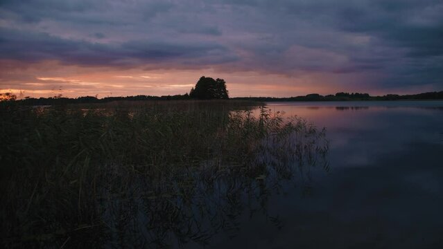 Summer sunset sky. Panoramic landscape sunset in Nature park. Colourful sky. Belarus landscape. Sunset over river or lake. Empty water, silence 