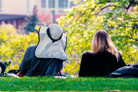 A couple is resting in a spring garden lying on a green meadow.