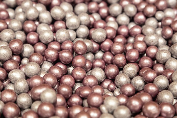 Silver and pink hazelnuts candy background, close-up.