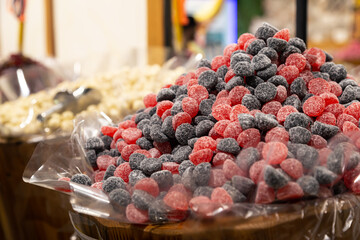 Close up of red and black candy in container in candy shop.