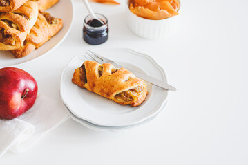 Apple cinnamon pastry rolls on white wooden table