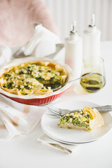 Quiche. Healthy homemade chicken pie with broccoli and spinach on white wooden table