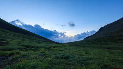 Distant storm clouds in quiet valley near Mt. Asahidake summit at blue hour - 643970993