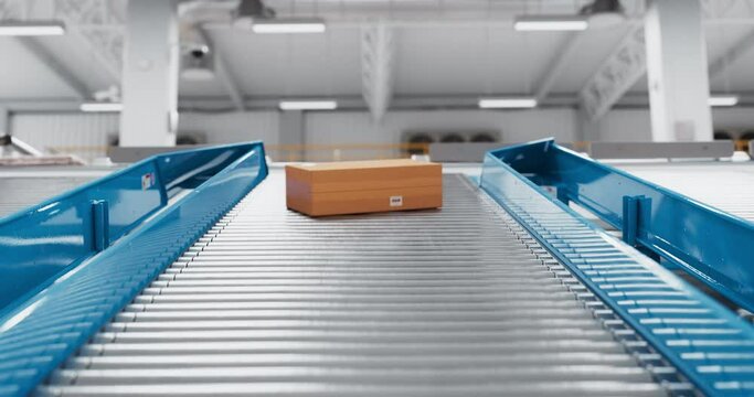 Cardboard Boxes with Ordered Goods Sliding Down an Automated Conveyor Belt in a Logistics Center. Automatic Engineering Solution Handling and Preparing Parcels for Delivery to International Customers