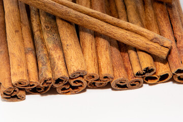 A close-up of a pile of vanilla sticks on a white background