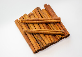 Many cinnamon sticks on a white background