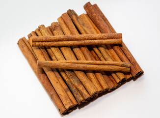 A close-up of a pile of vanilla sticks on a white background