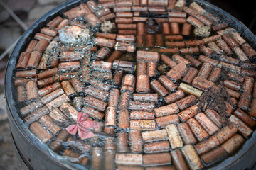 A barrel filled to the brim with rainwater and wine corks