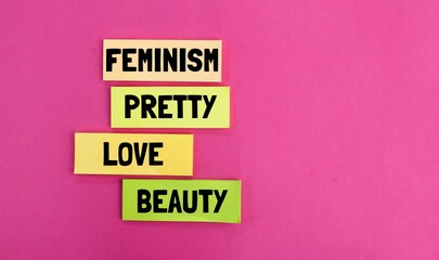 colored paper with the words beauty, love, feminism and pretty. the concept of femininity. about...