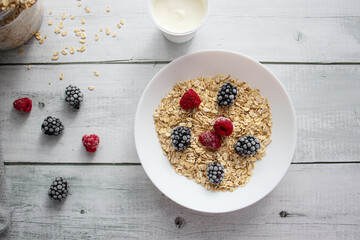 Oatmeal with berries. wooden on a white background. Breakfast