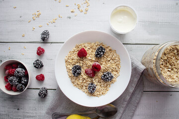 Oatmeal with berries. wooden on a white background. Breakfast