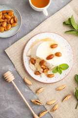 Ricotta cheese with honey and almonds on gray concrete. top view, flat lay, close up.