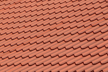 close up of roof of house covered with red metallic tiles