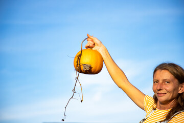 woman holding pumpkin in harvest season