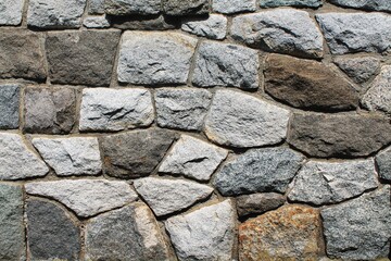 Rock wall horizontal mosaic pattern with irregular stones and contrasting mortar