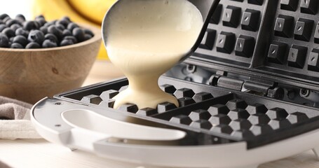 Liquid dough poured waffle iron machine to prepare Belgian waffle. Food preparation. Close up shot. 