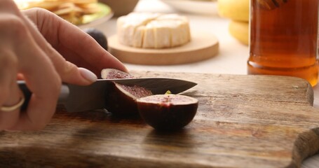 Figs are cut on a cutting board. Preparing appetizers. Tasty food. Close-up.