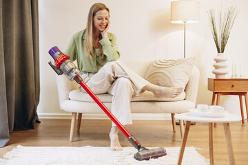 Woman doing house work and using wireless vacuum cleaner