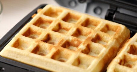 Belgian waffle in a waffle iron close-up. High quality photo