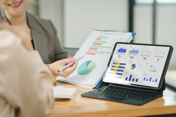 Businesswoman advisor team are analyzing data charts, graphs, and a dashboard on a laptop screen in order to prepare a statistical report and discuss financial data in an office.