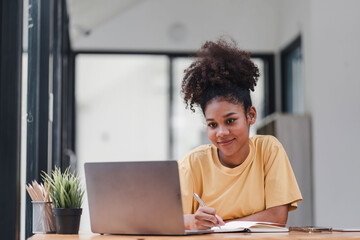 African American businesswoman or accountant with afro hair using a calculator, graphs, and charts to analyze market data, balance sheets, accounts, and net profits.