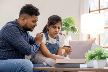Obraz premium A young couple is stressed over credit card charges used for online purchases.