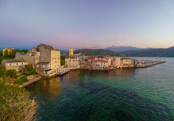 Fototapeta na wymiar Corse (France) - Corsica is a big touristic french island in Mediterranean Sea, with beautiful beachs and mountains. Here a view of the historical center of Saint Florent port village at sunset