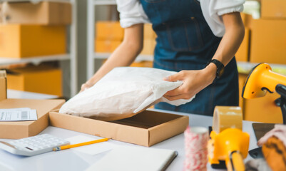 Online small business owners are packing their ordered products that customers order online into a...