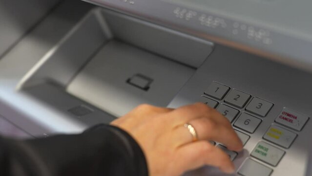 Hand enter pin code in cash machine, close-up