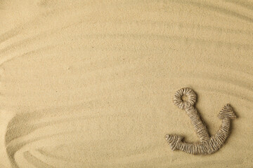 Fototapeta na wymiar Columbus Day. An anchor woven from a rope on the sand