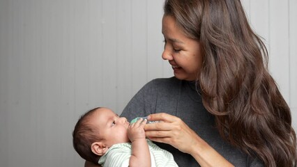 Young mother feeding her little baby with milk baby bottle
