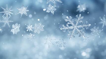 A closeup of snowflakes swirling in the wind against a grey sky background.