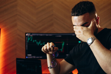 Man trader sitting by his coputer working on exchange market