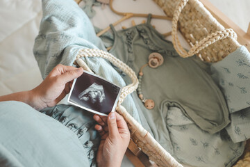 Ultrasound picture pregnant baby photo. Woman holding ultrasound pregnancy image. Concept of...