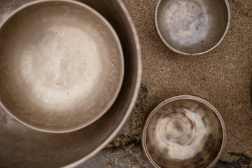 Vista cenital de cuencos tibetanos sobre arena de playa