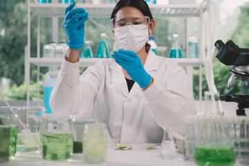 Chemist drop fluid of a bottle in the product research laboratory. Scientist researcher dosing and...