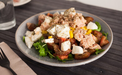 Fish salad with canned tuna and corn, tomatoes and arugula