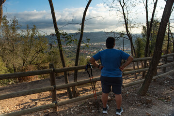 Overweight man stops his training to contemplate the landscape in the morning.