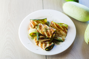 Grilled zucchini pieces with garlic sauce in a white plate.