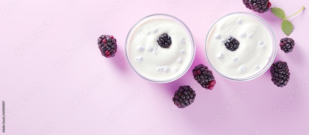 Poster front view of macro shot of wild berry topped white yogurt in two glasses on a isolated pastel backg